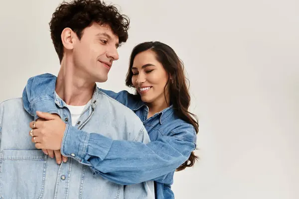 Couple enjoys a joyful moment, embracing each other while dressed in stylish denim outfits. — Stock Photo