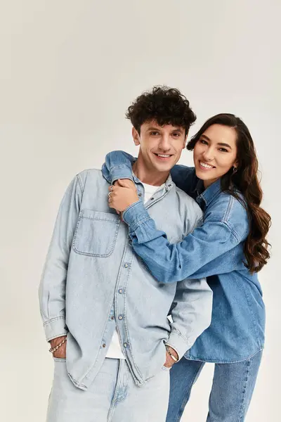 Two young friends show off their stylish denim outfits while playfully embracing in a chic space. — Stock Photo