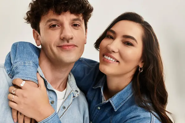 A stylish young couple smiles in trendy denim outfits in a bright, cheery setting. — Stock Photo