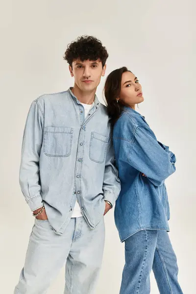Two young individuals show off trendy denim outfits in a bright, stylish space. — Stock Photo