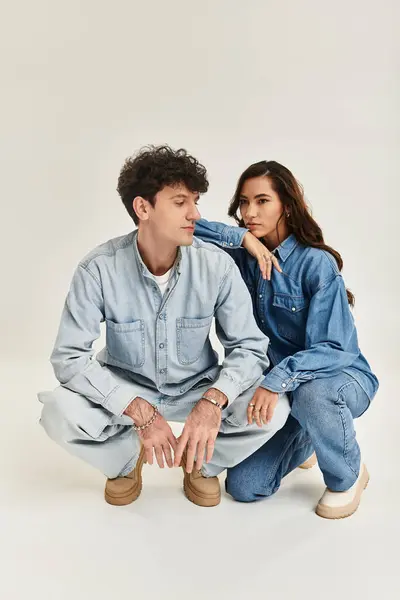 A fashionable young couple poses in coordinated denim outfits, exuding contemporary style and charm. — Stock Photo