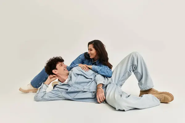 Stylish young couple engages in playful interactions while modeling fashionable denim outfits. — Stock Photo