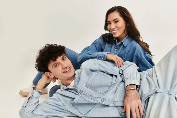 Una pareja joven y elegante se relaja en mezclilla a juego, exudando confianza y estilo moderno. - foto de stock
