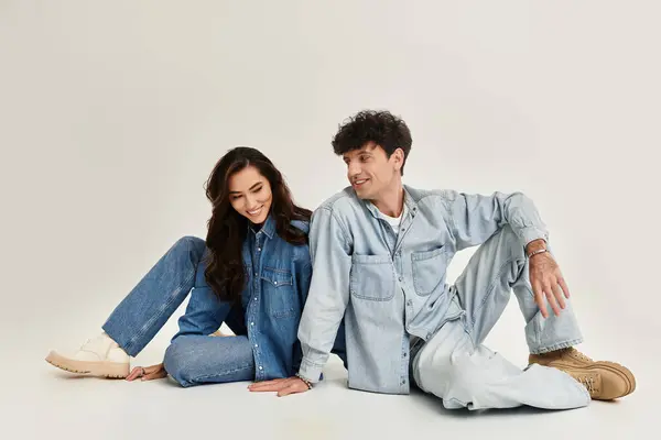 Two stylish individuals relax in a modern studio, showcasing their chic outfits. — Stock Photo