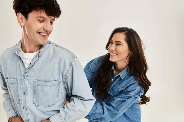 A young couple plays in a modern studio, showing off their trendy denim outfits. — Stock Photo