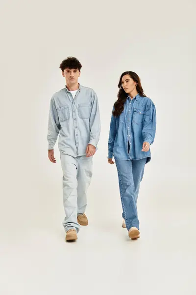 A young couple confidently showcases their trendy denim in a chic setting. — Stock Photo