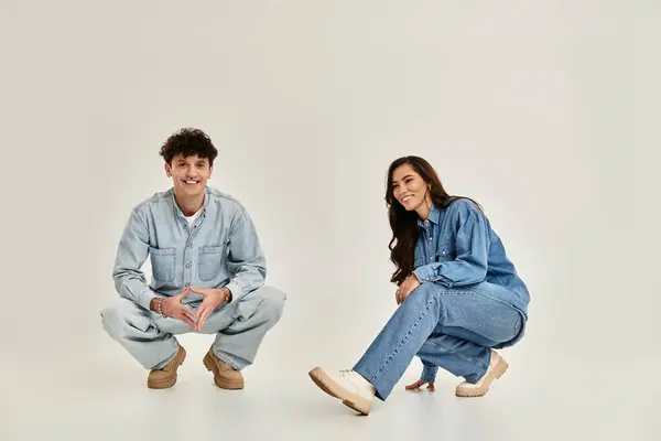 Two fashionable young people showcase their trendy denim styles while having fun indoors. — Stock Photo
