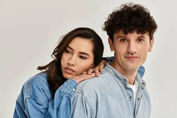 Two stylish individuals showcase modern fashion trends with a cozy connection in a chic studio. — Stock Photo