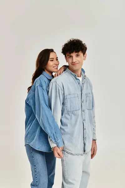 A fashionable young couple showcases their trendy denim outfits in a bright, modern studio. — Stock Photo