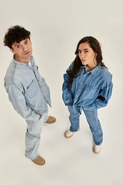 A young couple poses confidently in matching denim outfits, exuding modern fashion vibes. — Stock Photo