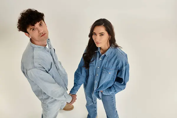 Stylish young couple poses confidently in matching denim outfits with a clean, modern vibe. — Stock Photo