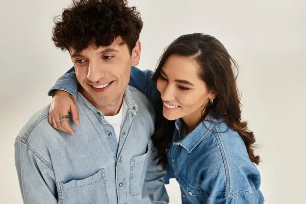 Young couple smiles warmly while embracing, showcasing trendy denim fashion and effortless style — Stock Photo