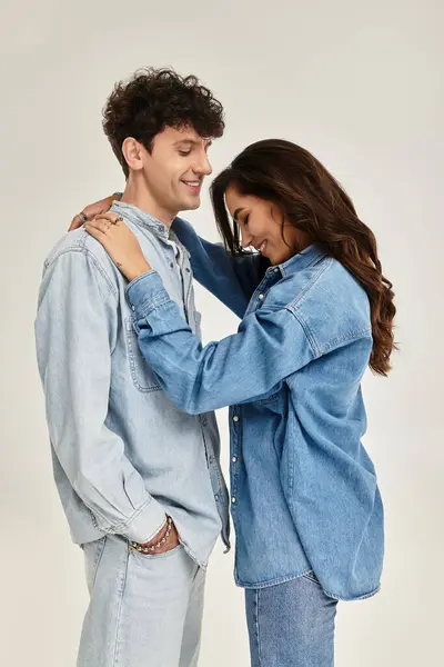 Two young individuals share a joyful moment in fashionable denim outfits, exuding youthful flair. — Fotografia de Stock