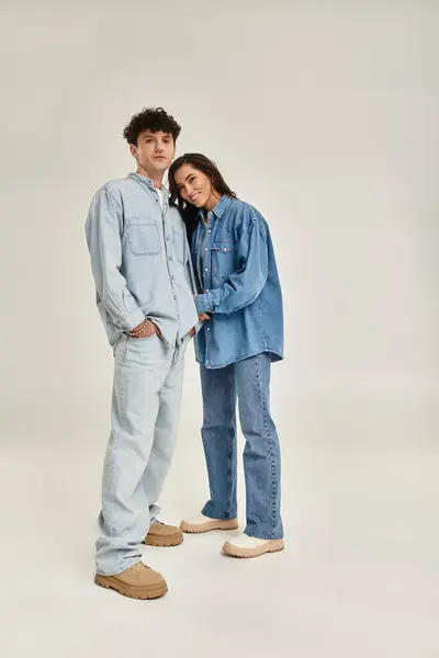 Young couple poses playfully in trendy denim outfits, embodying a fashionable and modern aesthetic. — Stock Photo