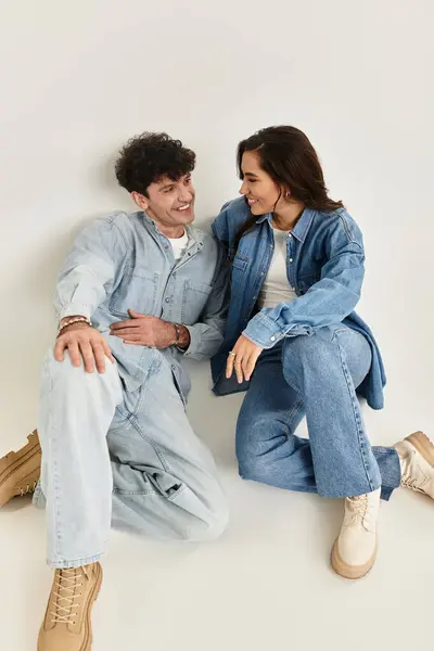 Fashionable young pair share smiles while dressed in trendy denim, radiating style and joy. — Stock Photo