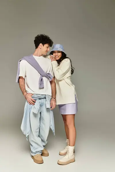 A young couple dressed in stylish attire shares a playful moment in a modern fashion shoot. — Stock Photo