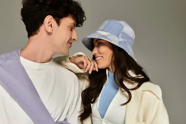 A fashionable duo enjoys an intimate exchange while showcasing modern style elements in soft hues. — Stock Photo