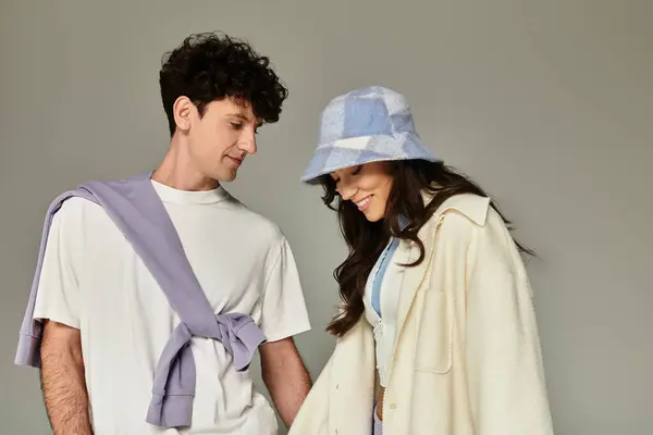 A trendy couple is sharing smiles while showcasing their stylish outfits in a chic studio. — Stock Photo