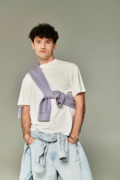 Fashionable young man stands confidently in a modern outfit, expressing contemporary style. — Stock Photo