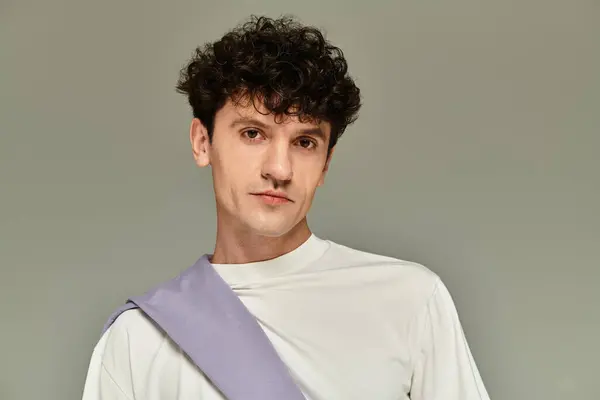 A stylish young man poses confidently against a neutral background, exuding modern fashion vibes. — Stock Photo