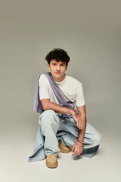Stylish young individual poses confidently in a trendy outfit with a relaxed expression in studio. — Stock Photo