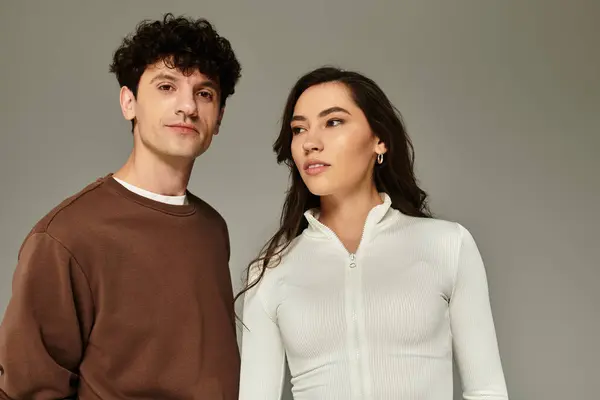 A young couple dressed in trendy outfits showcases their unique style in a contemporary space. — Stock Photo