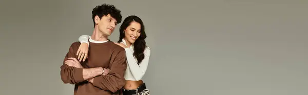 A young couple poses playfully in a trendy studio, radiating modern style and confidence. — Stock Photo
