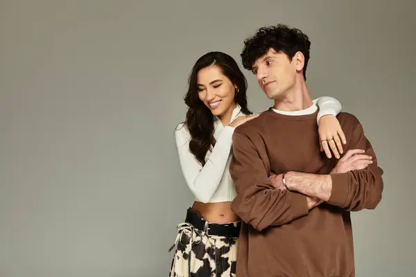 Charming young couple poses playfully in a modern studio, radiating confidence. — Stock Photo