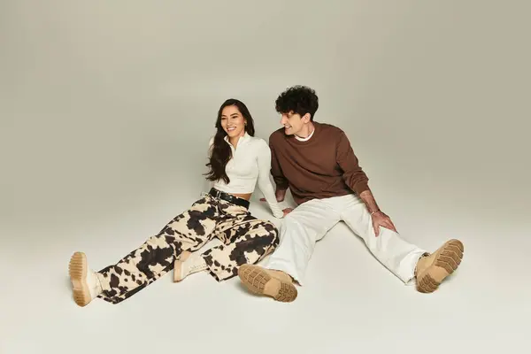 Fashionable young individuals express their style through playful poses and trendy outfits indoors. — Stock Photo
