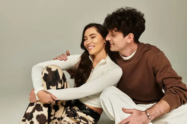 A fashionable young couple shares laughter and warmth in a contemporary studio, radiating style. — Stock Photo
