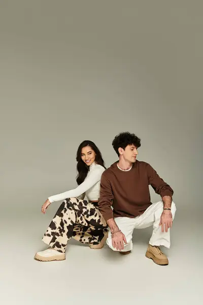 A young and fashionable couple poses together in a sleek studio, exuding style and confidence. — Stock Photo