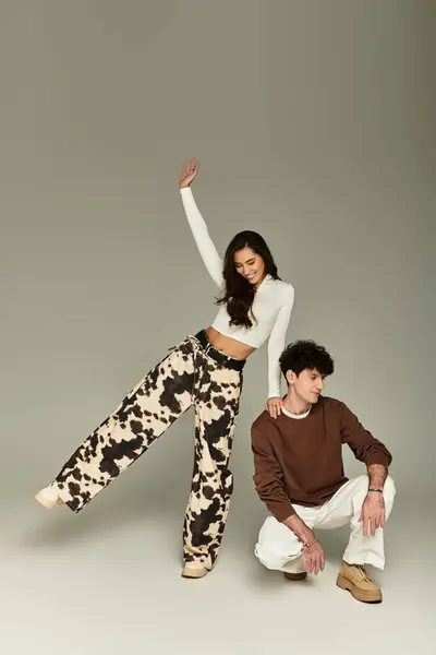 Young, fashionable individuals engage in playful poses, highlighting contemporary trends in style. — Stock Photo