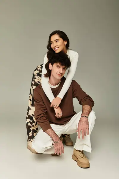 A young couple showcases their trendy outfits in a minimalist studio, exuding confidence and style. — Stock Photo