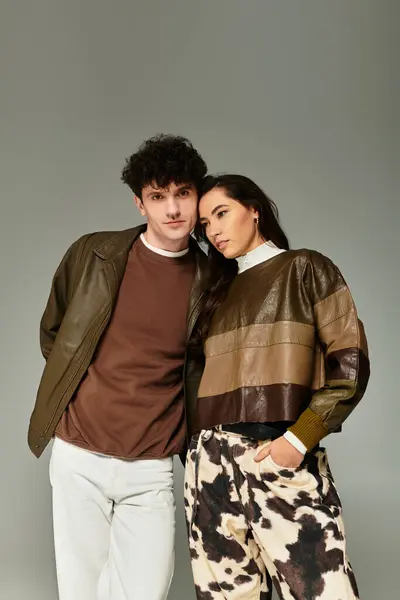 A young couple embodies trendy fashion with unique outfits in a minimalist studio background. — Stock Photo