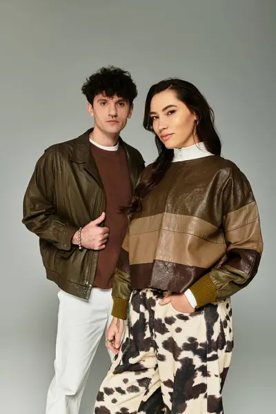 A fashionable couple poses confidently in a contemporary studio, radiating style and charm. — Stock Photo