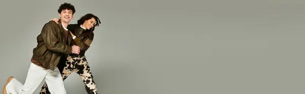 Young couple joyfully interacts, displaying stylish outfits in a chic and contemporary studio. — Stock Photo
