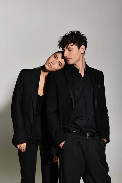 A stylish young couple displays their fashion while posing together in a chic studio. — Stock Photo