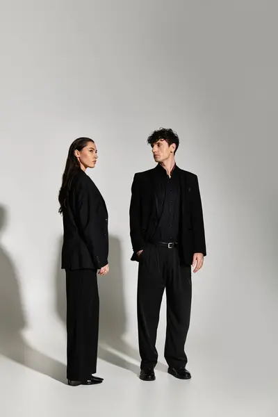 Two stylish individuals in sleek black outfits exude modern elegance and confidence. — Stock Photo
