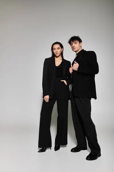 Trendy pair stands confidently in chic black outfits, capturing the essence of contemporary style. — Stock Photo
