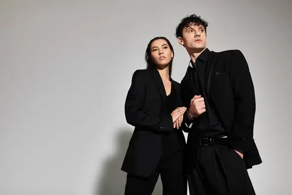 A young couple poses confidently in trendy black outfits, showcasing contemporary fashion styles. — Stock Photo