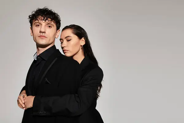 Stylish couple poses confidently against a minimalist backdrop, showcasing contemporary fashion. — Stock Photo
