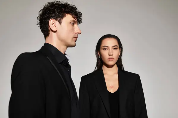 Two young trendsetters showcase contemporary style in a sleek, minimalist atmosphere. — Stock Photo
