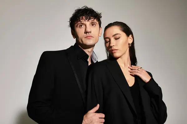 A fashionable young couple poses confidently in matching black attire, showcasing modern style. — Stock Photo