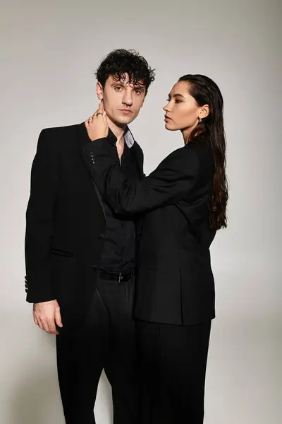 A fashionable young couple displays contemporary style in sleek black outfits, radiating confidence. — Stock Photo