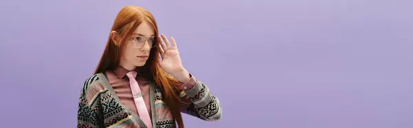 A young man with long red hair poses stylishly against a pastel background. — Stock Photo