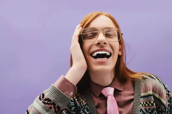 A young queer man with long red hair and glasses joyfully poses in a stylish outfit. — Stock Photo