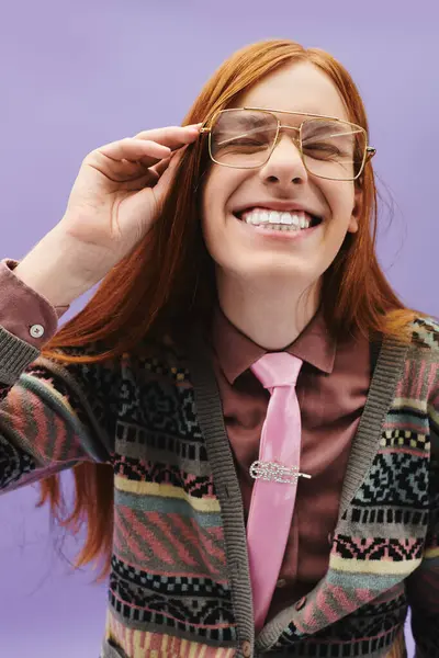 Stylish young man with long red hair and glasses smiles enthusiastically in a pink tie. — Stock Photo