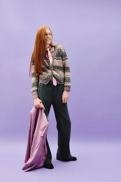 A fashionable young queer man stands confidently in trendy attire against a soft purple backdrop. — Stock Photo