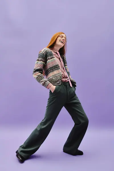 A young queer man confidently poses in stylish clothes against a purple backdrop. — Stock Photo