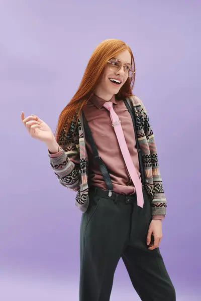 A fashionable queer man with long red hair showcases his unique style against a vibrant backdrop. — Stock Photo